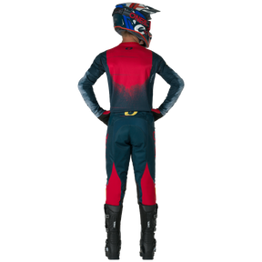 Una persona vestida con pantalones SWIPE de O'NEAL Hardwear, casco y botas negras, de pie, con las manos en las caderas y mirando hacia otro lado.