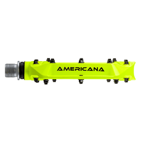 Un pedal AZONIC AMERICANA amarillo brillante con varias conexiones metálicas pequeñas y un extremo roscado, aislado sobre fondo negro.