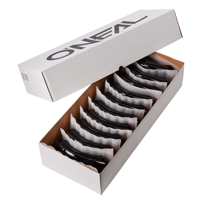 Eine weiße rechteckige Schachtel mit der Aufschrift "O'NEAL" enthält 10 einzeln verpackte schwarze O'NEAL B-ZERO Goggles, die ordentlich in separaten Fächern angeordnet sind, wobei der Deckel teilweise geöffnet ist.