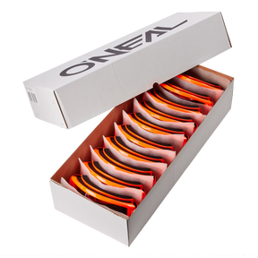 Eine weiße O'NEAL-Schachtel mit der Aufschrift "O'NEAL B-ZERO Goggle 10pcs" enthält 10 orangefarbene und schwarze O'NEAL B-ZERO-Schutzbrillen, jede ordentlich in ihrem eigenen Fach mit teilweise geöffnetem Deckel angeordnet.