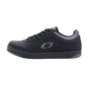 La chaussure O'NEAL PUMPS FLAT est une chaussure de sport basse noire avec des accents gris, des lacets noirs et un logo O'NEAL stylisé sur le côté - idéal pour l'associer à tes accessoires de vélo préférés.