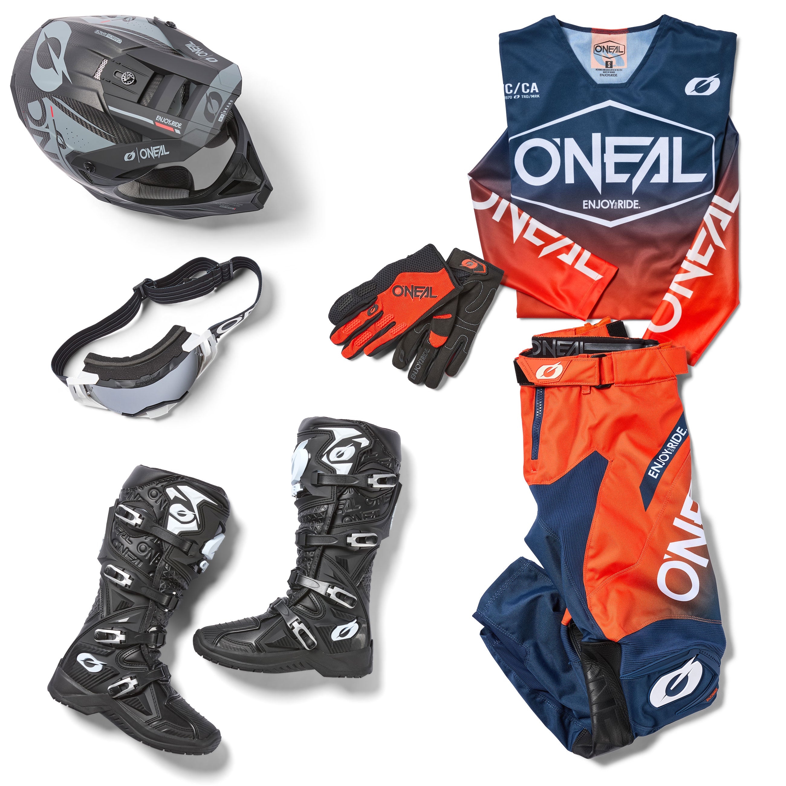 Auf weißem Hintergrund abgebildetes Motorrad-Ausrüstungsset, bestehend aus einem schwarzen Helm, einer Schutzbrille, roten und schwarzen Handschuhen, schwarzen Stiefeln und einem blau-rot-weißen Trikot und einer Hose mit der Marke O’Neal.